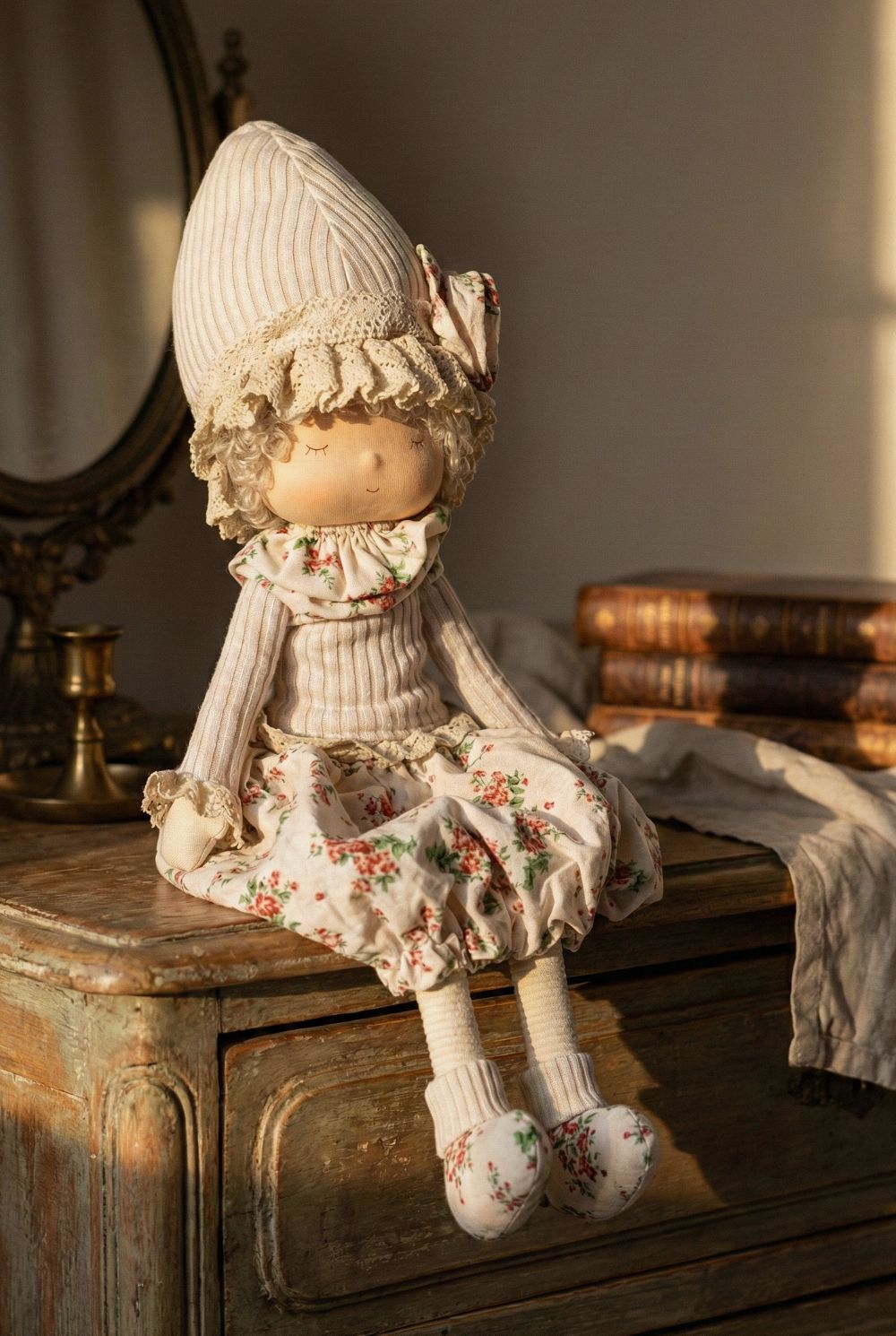 Poupée décorative bohème Liberty 45 cm en tissu beige et écru à motif floral rouge, style décoration romantique shabby chic, assise avec longues jambes souples dans une ambiance maison de charme.