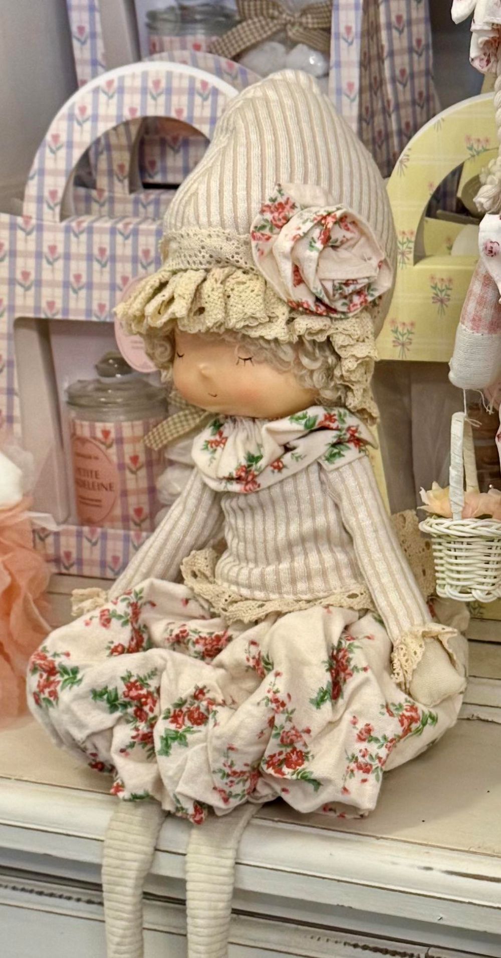 Poupée décorative bohème Liberty 45 cm en tissu beige et écru à motif floral rouge, style décoration romantique shabby chic, assise avec longues jambes souples dans une ambiance maison de charme.