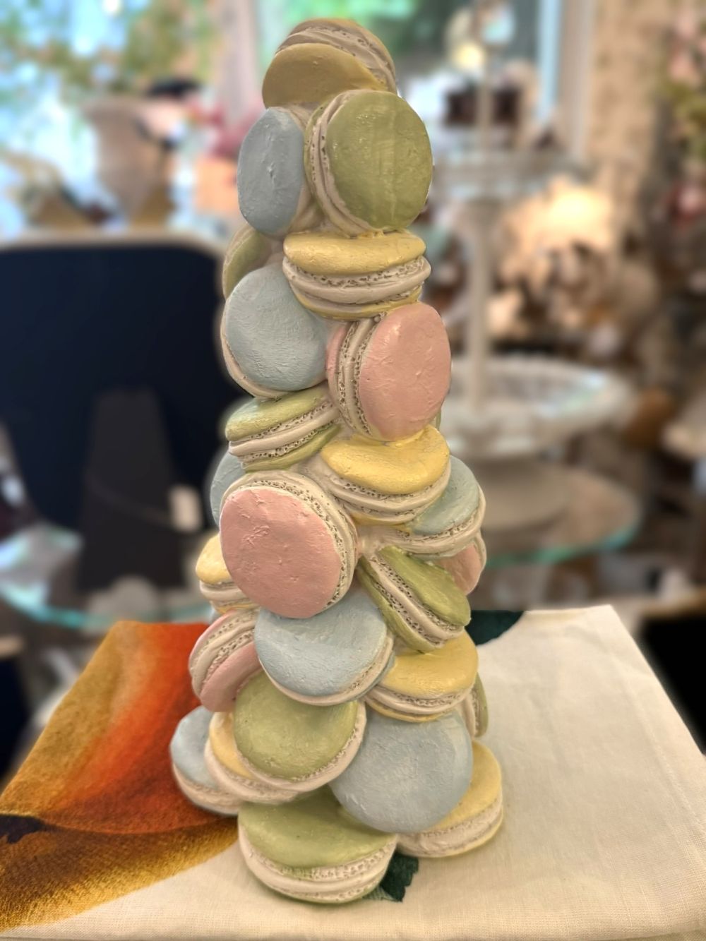 Pyramide décorative composée de macarons pastel roses, bleus, verts et jaunes, idéale pour une décoration romantique, gourmande et féérique de style shabby chic