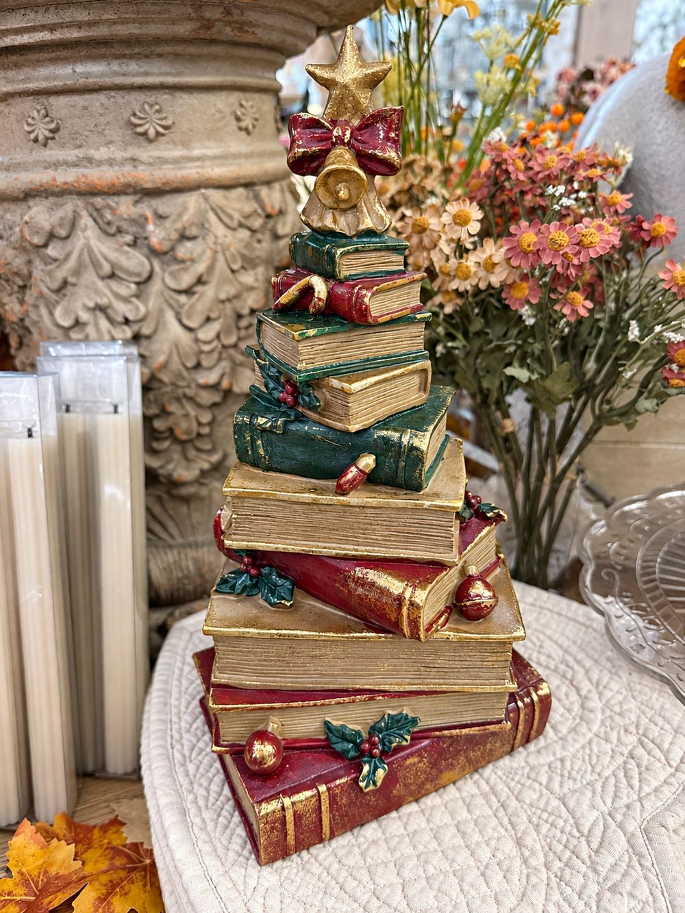 Figurine sapin de Noël composée de livres empilés rouges, verts et dorés, surmontée d’une étoile, décoration vintage et féérique à poser.