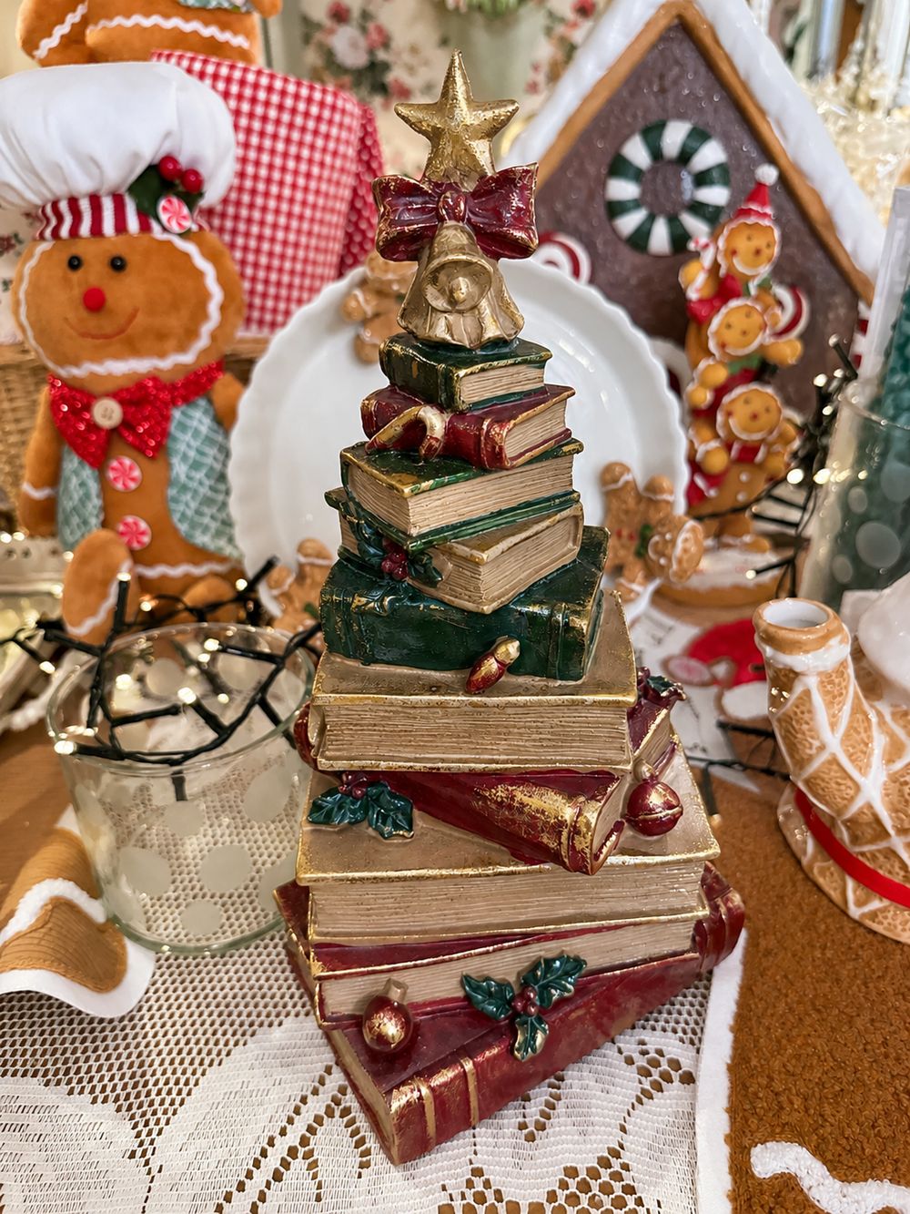 Figurine sapin de Noël composée de livres empilés rouges, verts et dorés, surmontée d’une étoile, décoration vintage et féérique à poser.