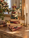 Figurine sapin de Noël composée de livres empilés rouges, verts et dorés, surmontée d’une étoile, décoration vintage et féérique à poser.