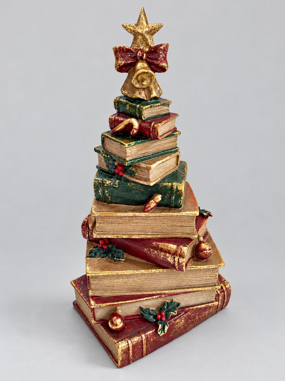 Figurine sapin de Noël composée de livres empilés rouges, verts et dorés, surmontée d’une étoile, décoration vintage et féérique à poser.