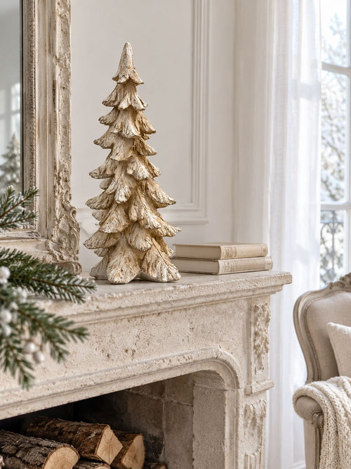 Sapin Roi des Neiges sur une cheminée en pierre claire, dans un salon lumineux aux tons ivoire.