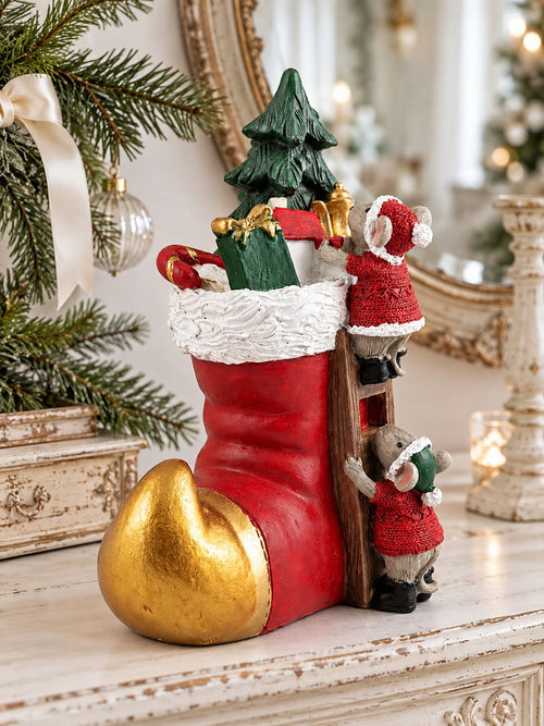 Soulier des Souris de Noël sur une console blanche patinée, devant un miroir ancien et des branches de sapin.
