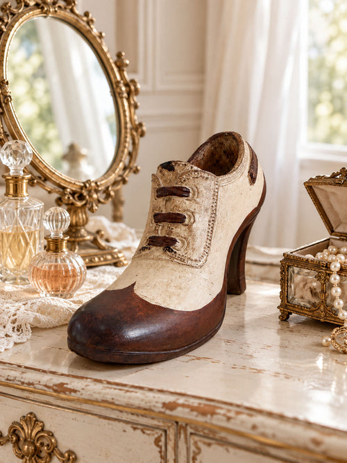 Soulier Victorien décoratif crème et brun posé sur une coiffeuse romantique ancienne