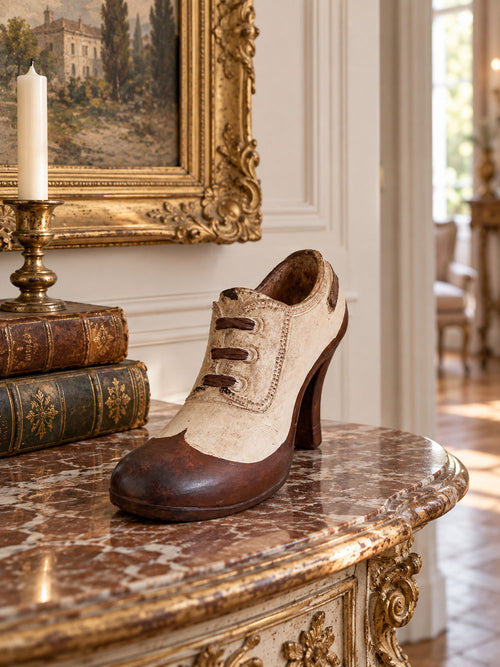 Soulier Victorien décoratif crème et brun posé sur une console d’entrée au charme ancien