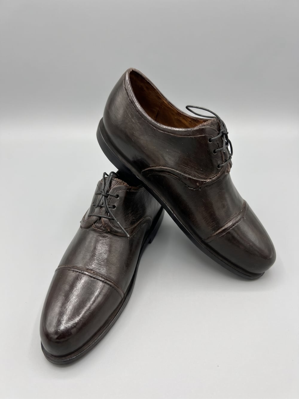 Paire de souliers décoratifs en métal noir patiné style ancien, posés sur un meuble de charme dans une ambiance vintage et romantique