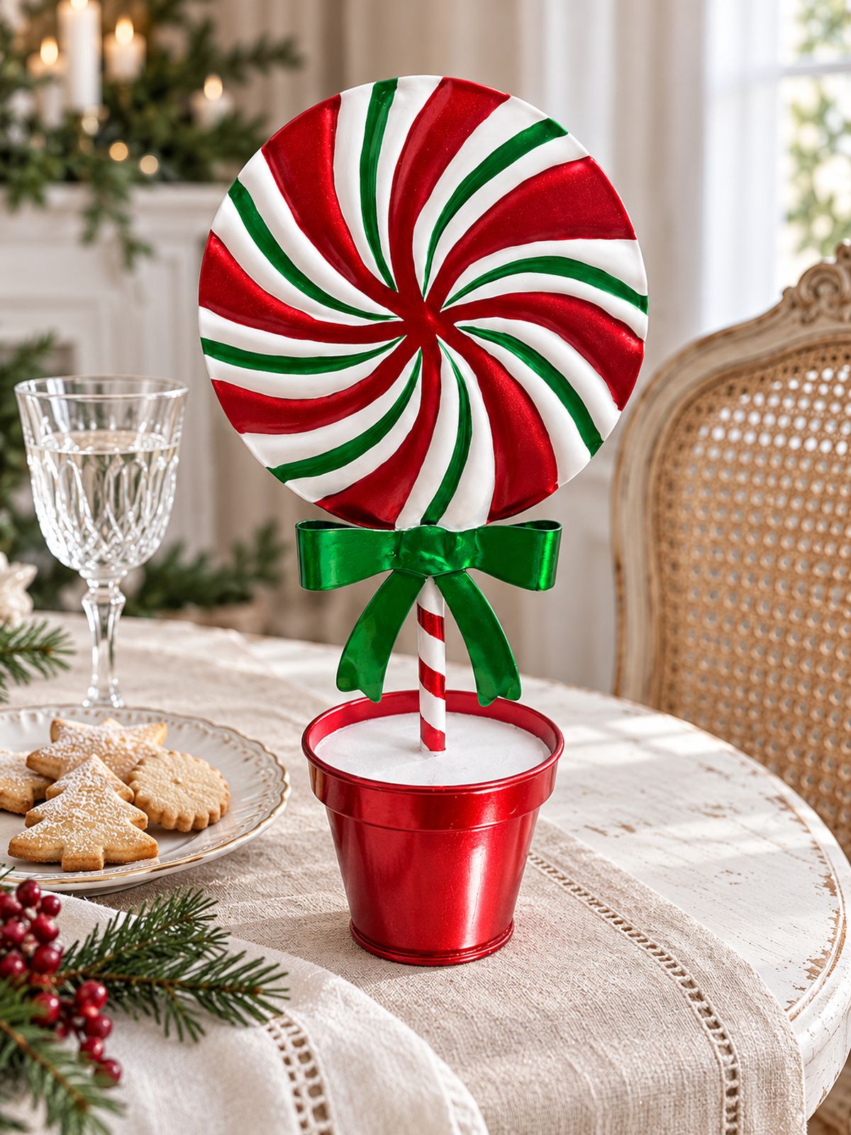 Sucette décorative de Noël de 26 cm à larges bandes vertes sur une table avec des biscuits et un verre à pied.