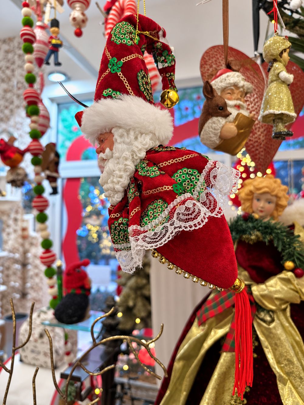 Vue de profil avec dos en tissu rouge et pompon de la suspension Père Noël de 33 cm, rouge avec ornements verts et dorés.