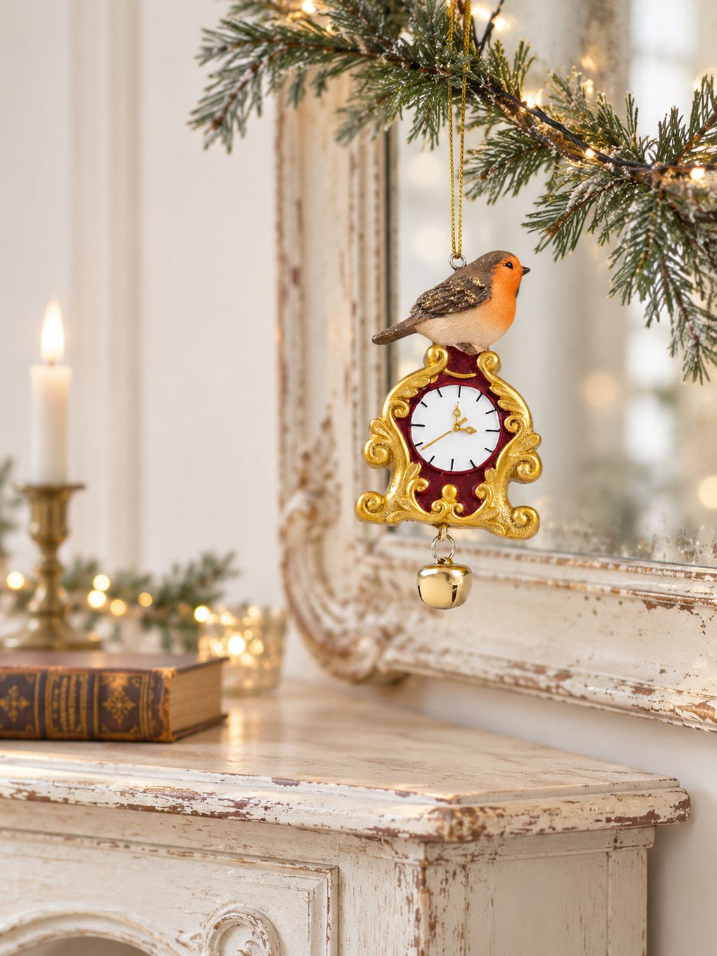 Suspension rouge-gorge à l’horloge devant un miroir ancien, au-dessus d’une console patinée décorée pour Noël.