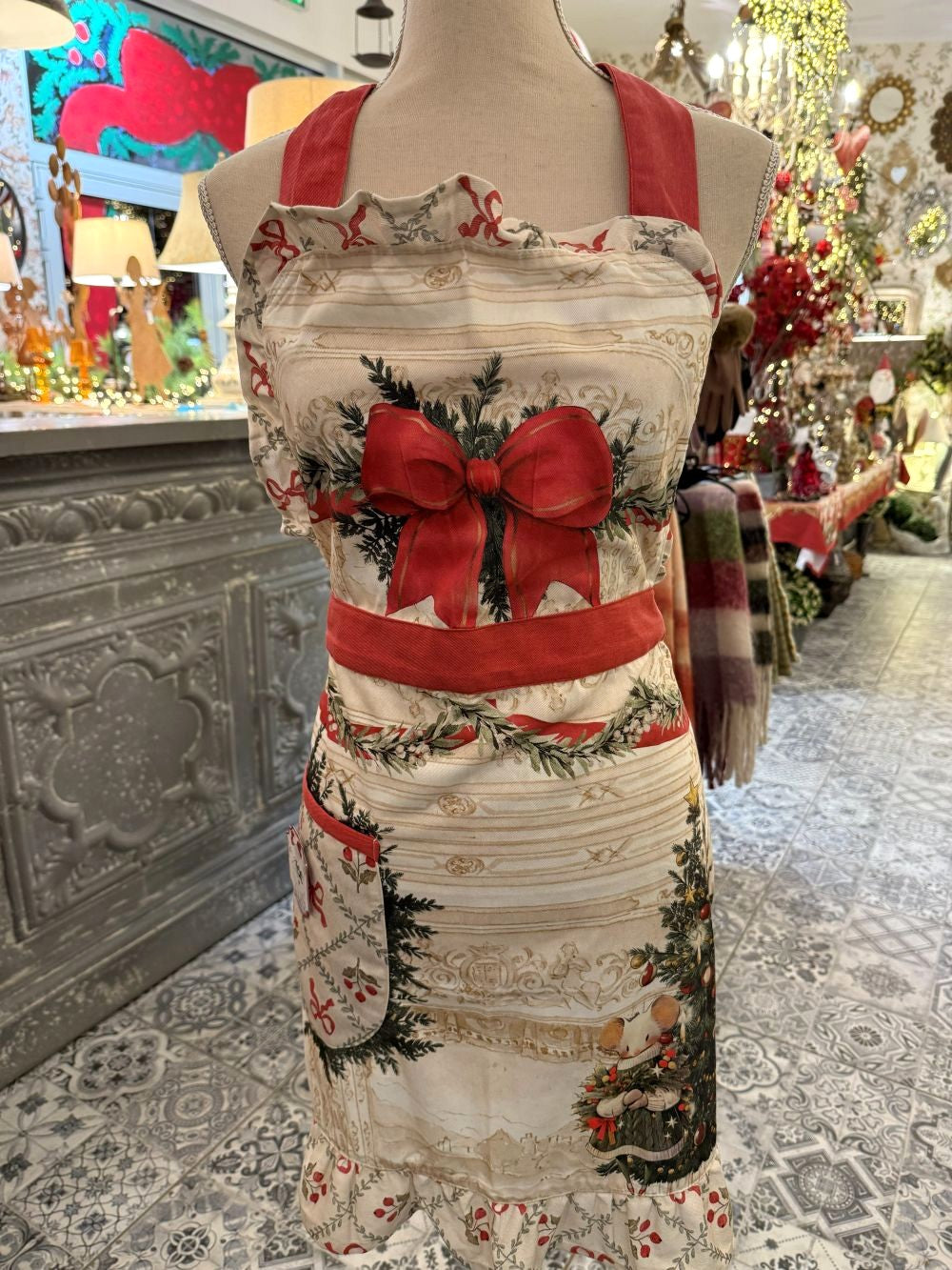 Tablier de Noël en coton Blanc Mariclò blanc rouge et vert, avec souris festive, grand nœud rouge et volant décoratif, style décoration romantique shabby chic pour cuisine de charme.