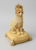 Tirelire décorative en forme de chat couronné, couleurs beige, doré et marron, style shabby chic romantique et poétique, posée sur un coussin élégant