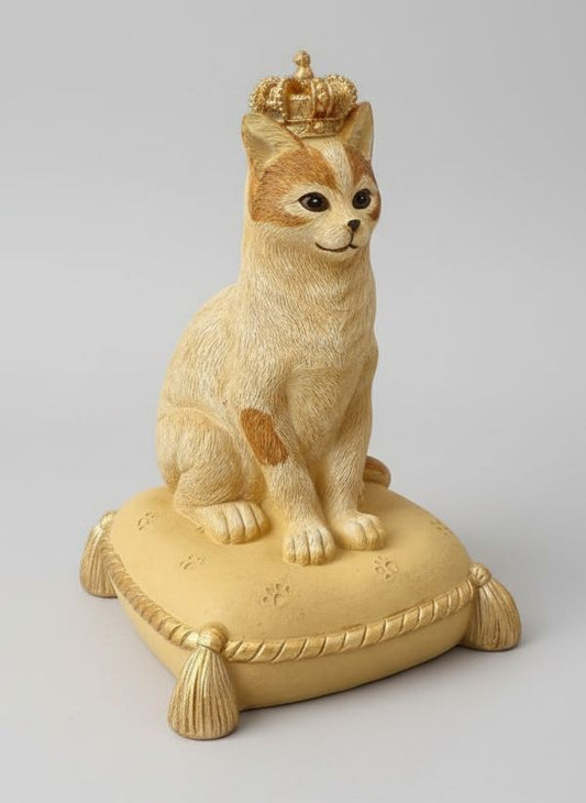 Tirelire décorative en forme de chat couronné, couleurs beige, doré et marron, style shabby chic romantique et poétique, posée sur un coussin élégant