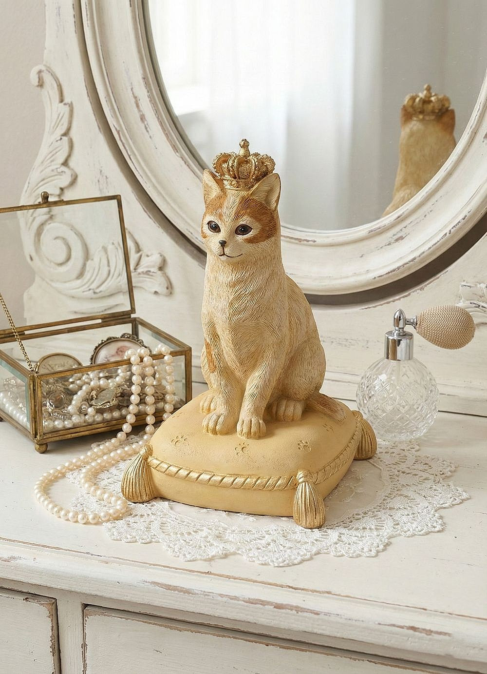 Tirelire décorative en forme de chat couronné, couleurs beige, doré et marron, style shabby chic romantique et poétique, posée sur un coussin élégant