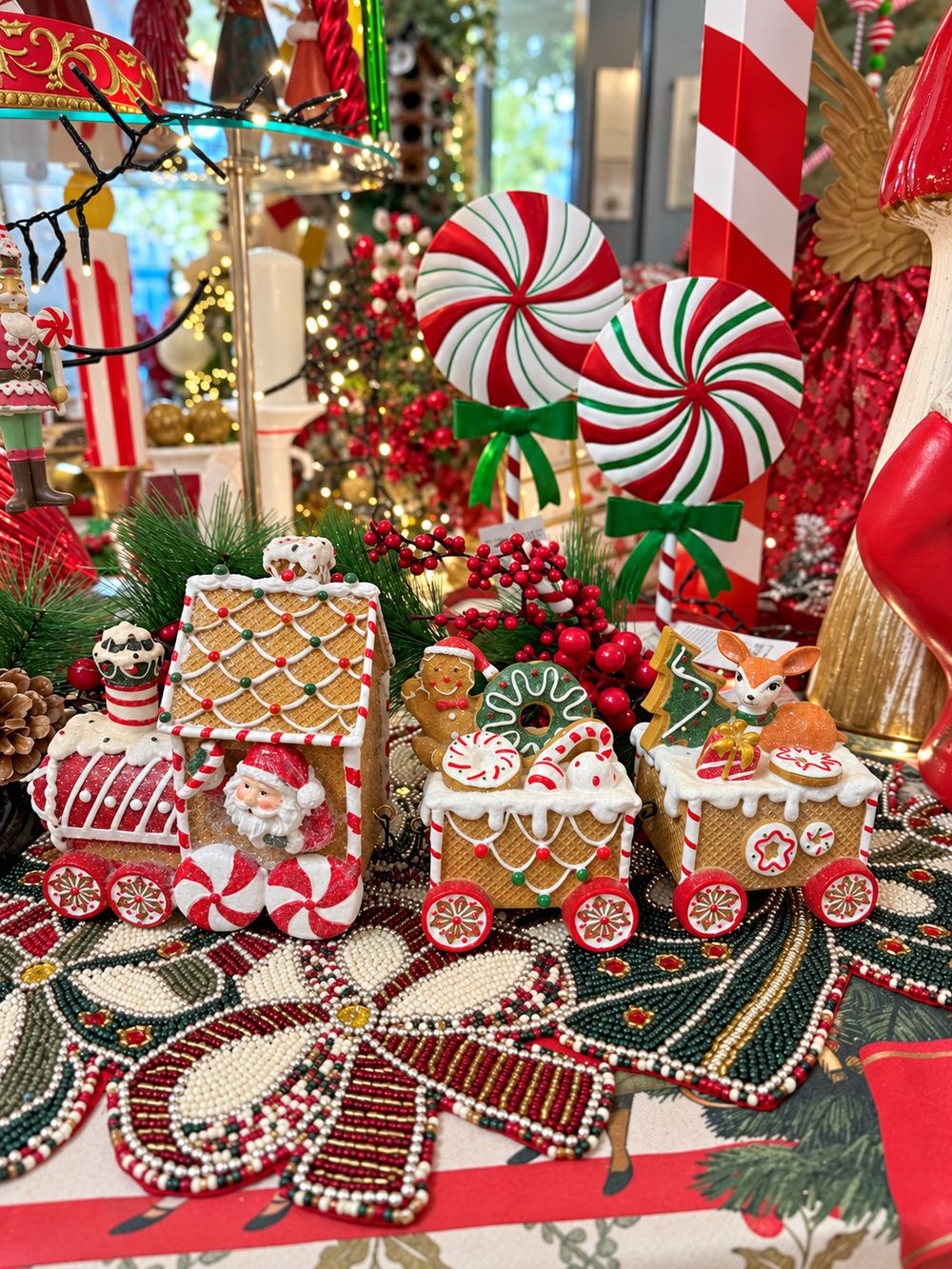 Vue d’ensemble du Train Enchanté du Père Noël, avec sa locomotive et ses deux wagons décorés de biscuits et de bonbons.