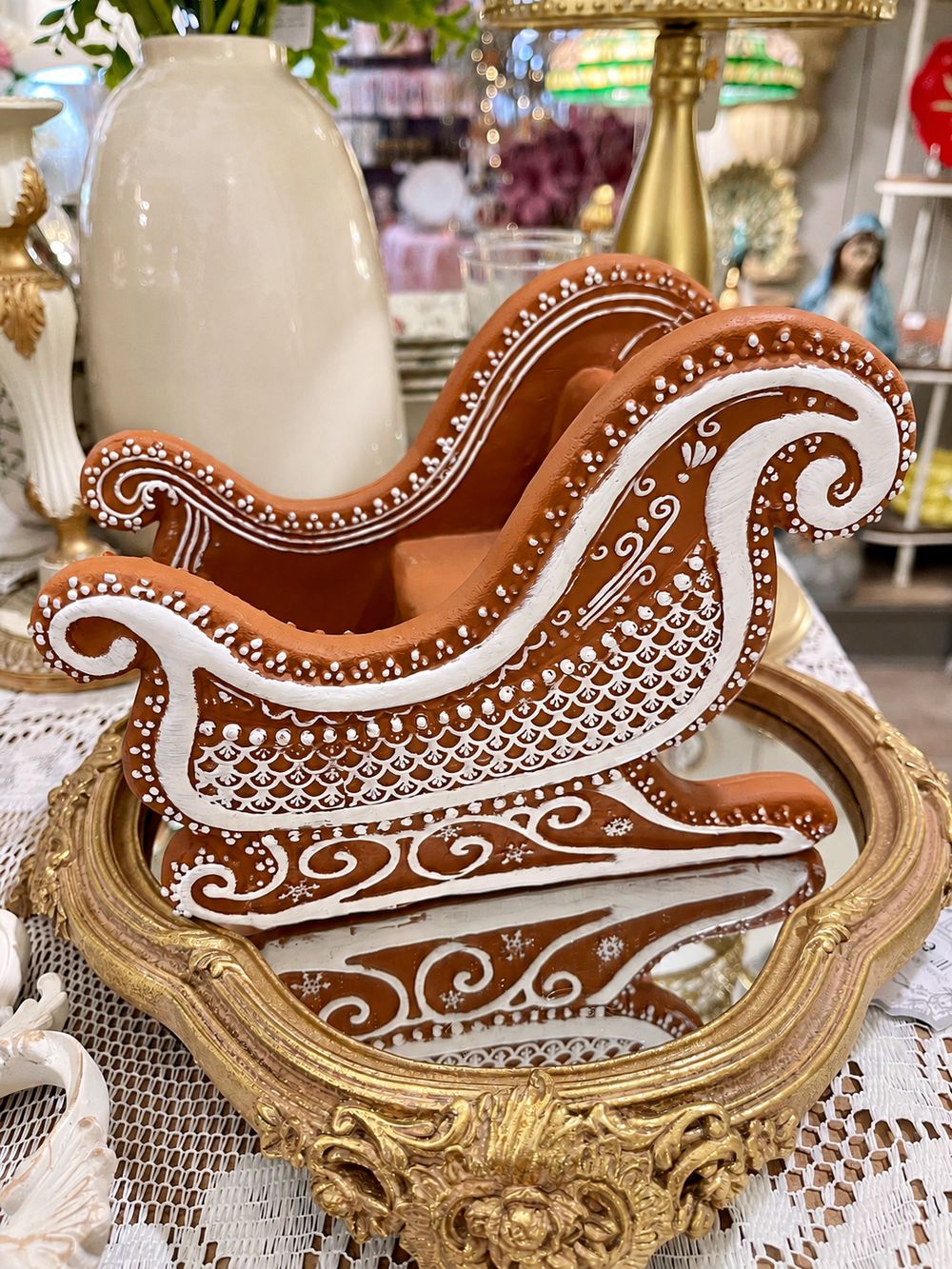 Traîneau Pain d’Épices en résine brune, vu de profil avec ses motifs blancs et ses patins décorés.