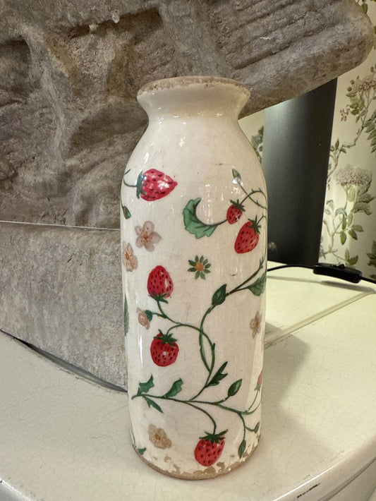 Vase décoratif en céramique blanc cassé avec motifs de fraises et fleurs, style shabby chic, ambiance romantique et bucolique, couleurs rouge, vert et blanc.