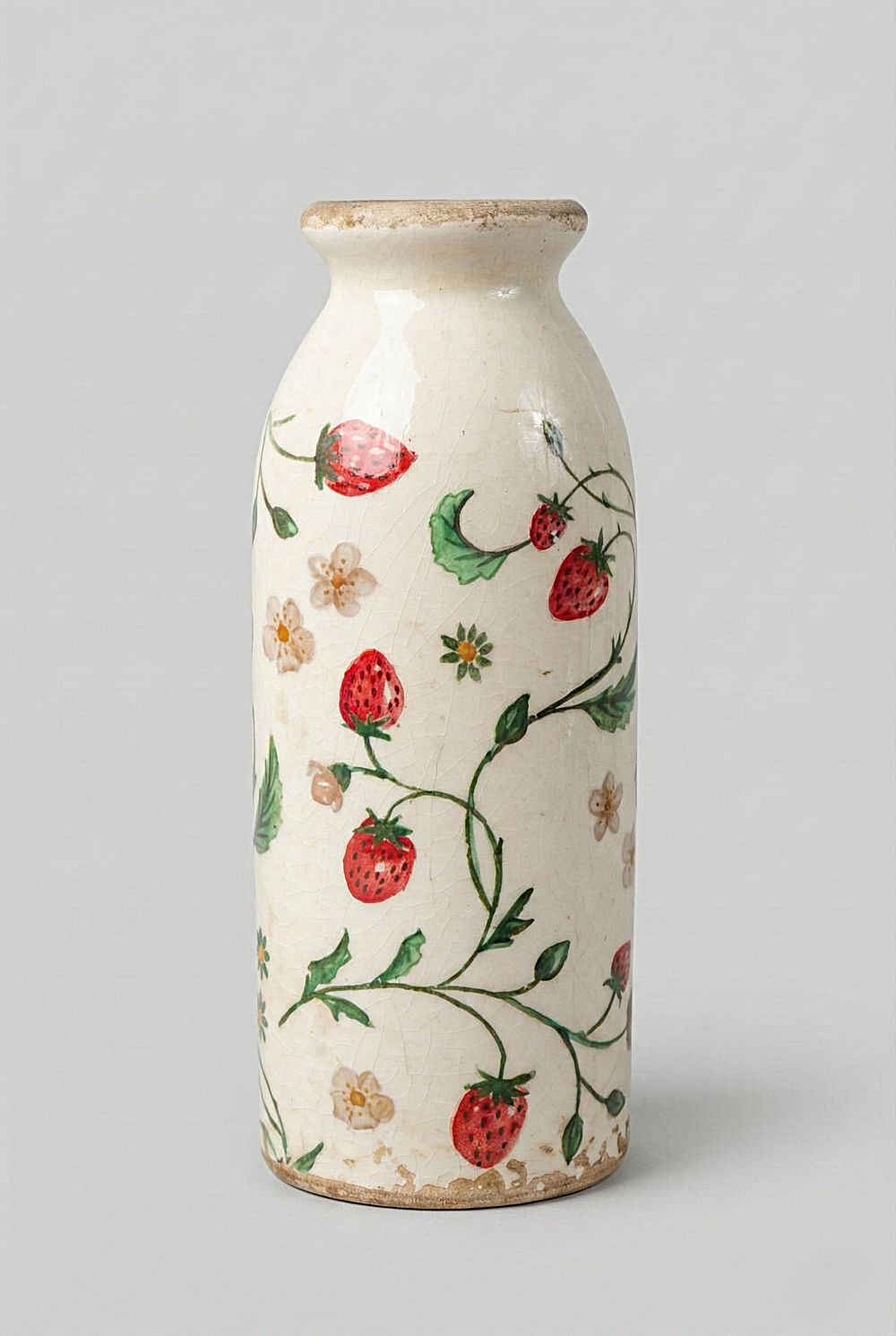 Vase décoratif en céramique blanc cassé avec motifs de fraises et fleurs, style shabby chic, ambiance romantique et bucolique, couleurs rouge, vert et blanc.